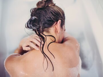 Frau mit nassen Haaren in der Badewanne | © GettyImages/Guido Mieth