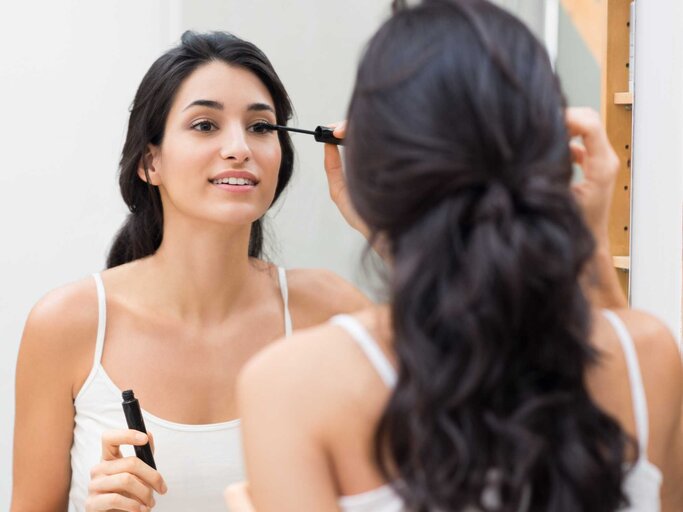 Frau trägt Mascara vor dem Spiegel auf | © Adobe Stock/Rido