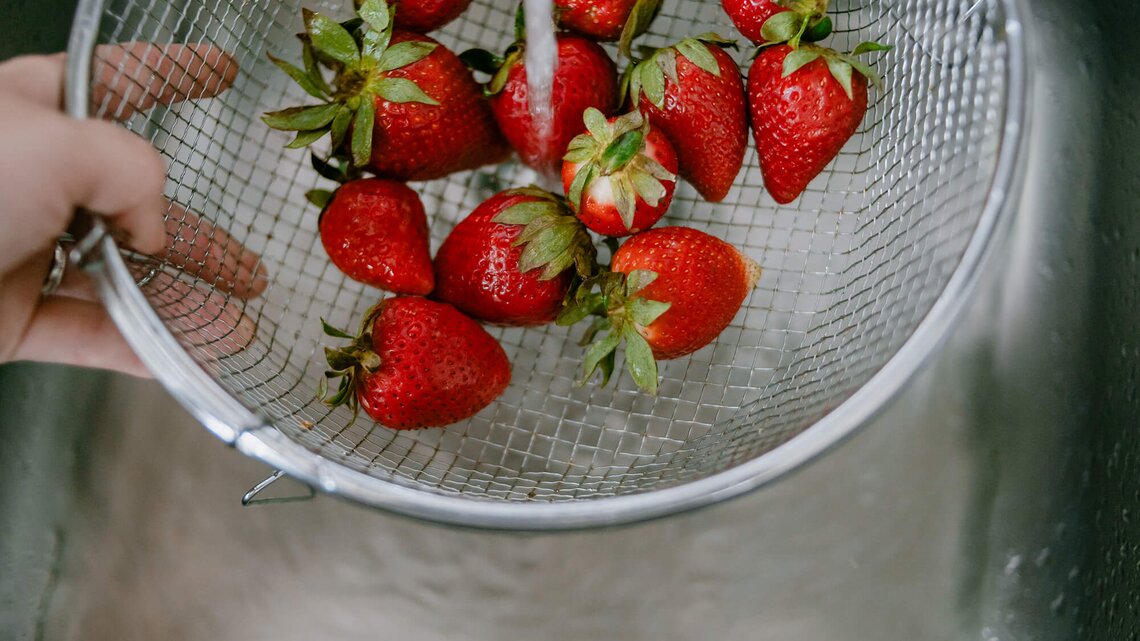 Erdbeeren werden mit Wasser gewaschen | © Getty Images/Ana Rocio Garcia Franco