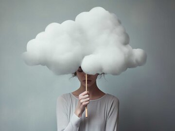 Frau hält eine Wolke an einem Stab über ihrem Kopf | © Adobe Stock/Virginie Verglas