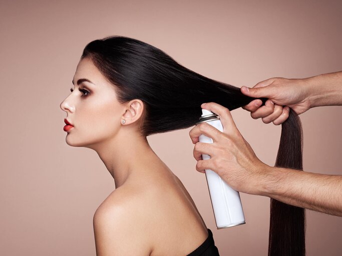 Frau bekommt Trockenshampoo in die Haare gesprüht | © Getty Images/heckmannoleg