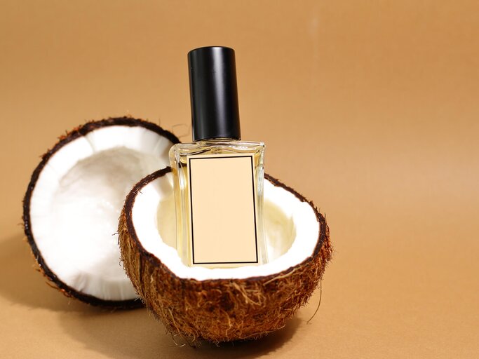 Parfum steht in einer Kokos-Schale | © Getty Images/Olga Berezhna