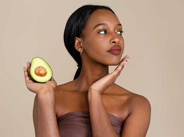 Junge Frau mit Avocado und toller Haut | © Getty Images/Phamai Techaphan