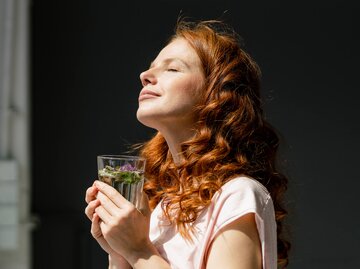 Frau mit roten Haaren steht in der Sonne | © Getty Images