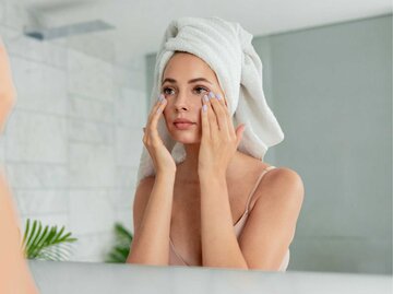 Junge Frau trägt nach dem Duschen Augencreme auf ihre Augen auf | © Adobe Stock/deniskomarov