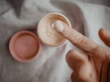 Finger mit Creme aus Tiegel | © Getty Images/Olesia Valentain / EyeEm