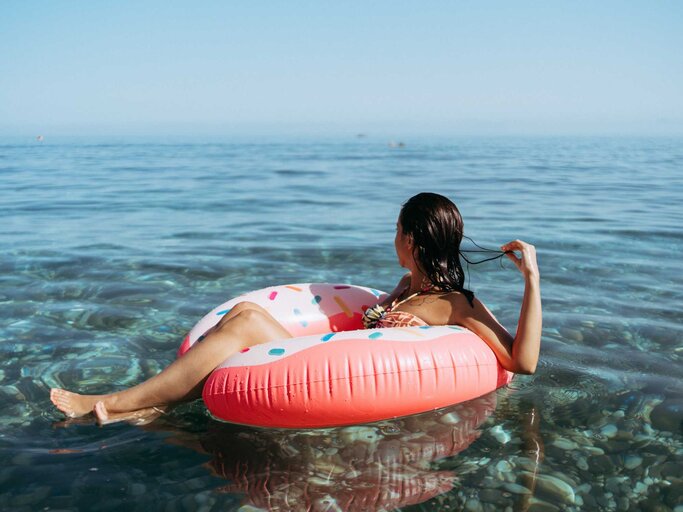 Frau sitzt auf einem Schwimmring im Meer | © Getty Images/Ana Rocio Garcia Franco