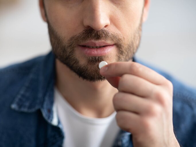 Mann nimmt eine Tablette | © Getty Images/Prostock-Studio
