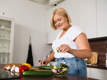 Frau bereitet sich Salat in Küche zu | © Getty Images/Inside Creative House