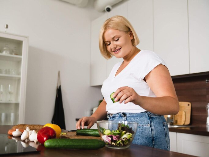 Frau bereitet sich Salat in Küche zu | © Getty Images/Inside Creative House