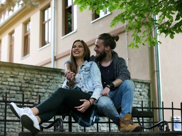Verliebtes Paar sitzt auf einer Bank | © Getty Images/Liderina