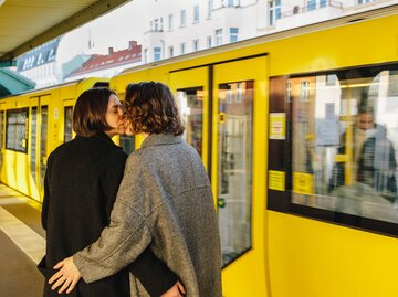 Paar küsst sich vor gelber Bahn | © Getty Images/Maskot