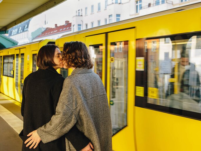 Paar küsst sich vor gelber Bahn | © Getty Images/Maskot