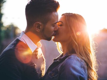 Glückliches Paar küsst sich vor der Sonne | © Getty Images/svetikd