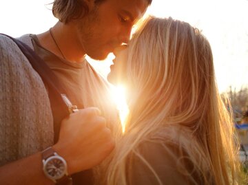 Junges Paar küsst sich vor der Sonne | © Adobe Stock/arthurhidden