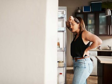 Frau steht hungrig vor dem Kühlschrank. | © Getty Images/PeopleImages