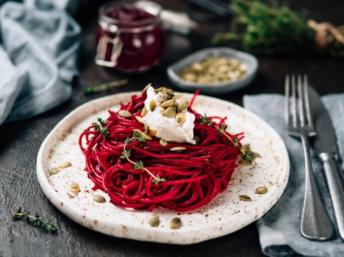 Ein Teller mit Rote Beete Pasta, etwas Mozzarella und Nüssen | © Getty Images/Fascinadora