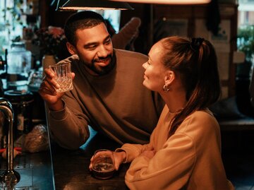 Zwei Personen flirten an der Bar | © Getty Images/Alina Rudya/Bell Collective