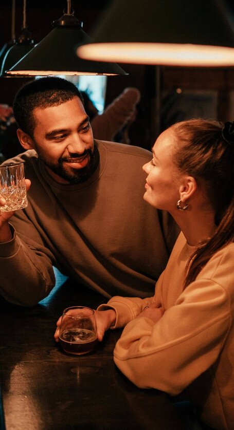 Zwei Personen flirten an der Bar | © Getty Images/Alina Rudya/Bell Collective