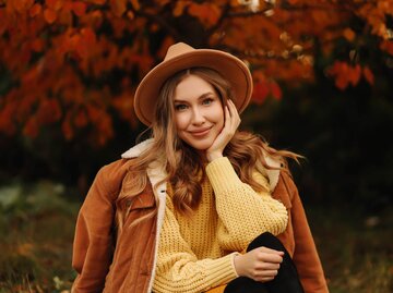 Person vor Herbstlaub mit Hut | © Getty Images/Elizaveta Starkova