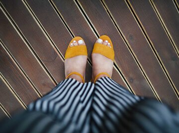Blick von oben auf ein paar gelbe Sandalen | © Getty Images/Maryna Terletska