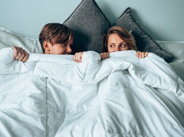 Mann und Frau liegen peinlich berührt im Bett | © Getty Images/	franckreporter