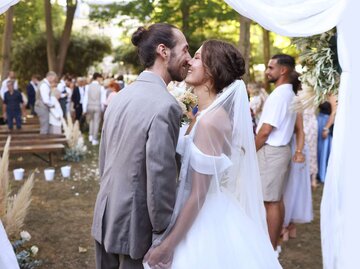Brautpaar küsst sich | © Getty Images/Catherine Delahaye