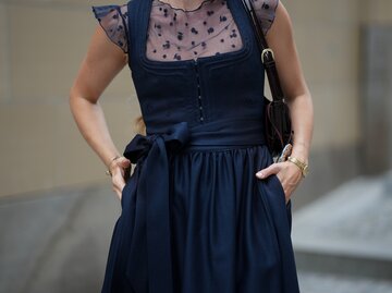 Model trägt dunkelblaues Dirndl | © GettyImages/	Moritz Scholz
