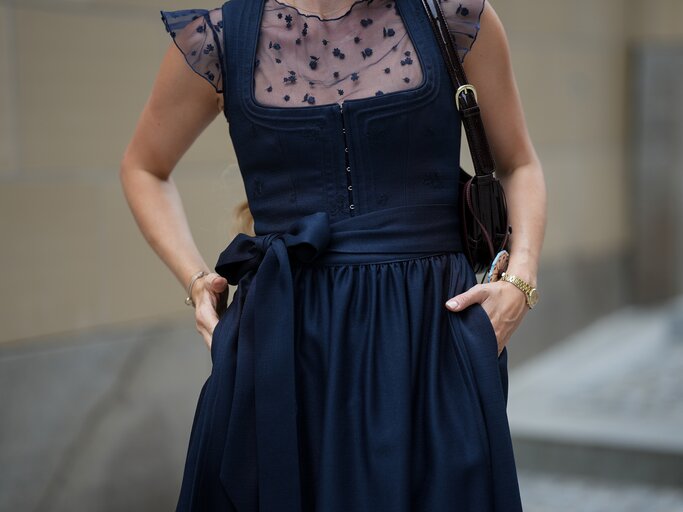 Model trägt dunkelblaues Dirndl | © GettyImages/	Moritz Scholz