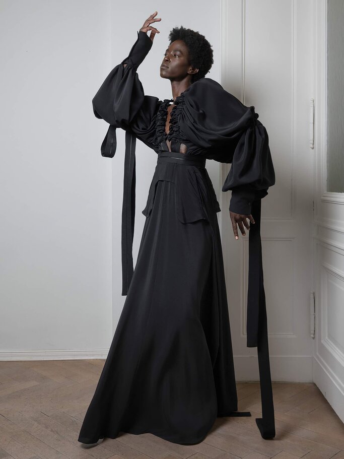 Model in schwarzem, drapiertem Kleid bei Esther Perbandt | © Sylwia Makris