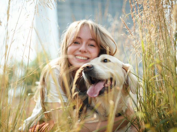 Person mit Hund im Gras | © Getty Images/LSOphoto