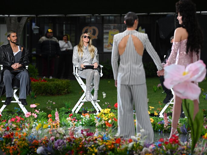 GNTM 2025: Heidi Klum in der Jury beobachtet zwei Personen auf dem Laufsteg. | © GettyImages/PG/Bauer-Griffin / Kontributor