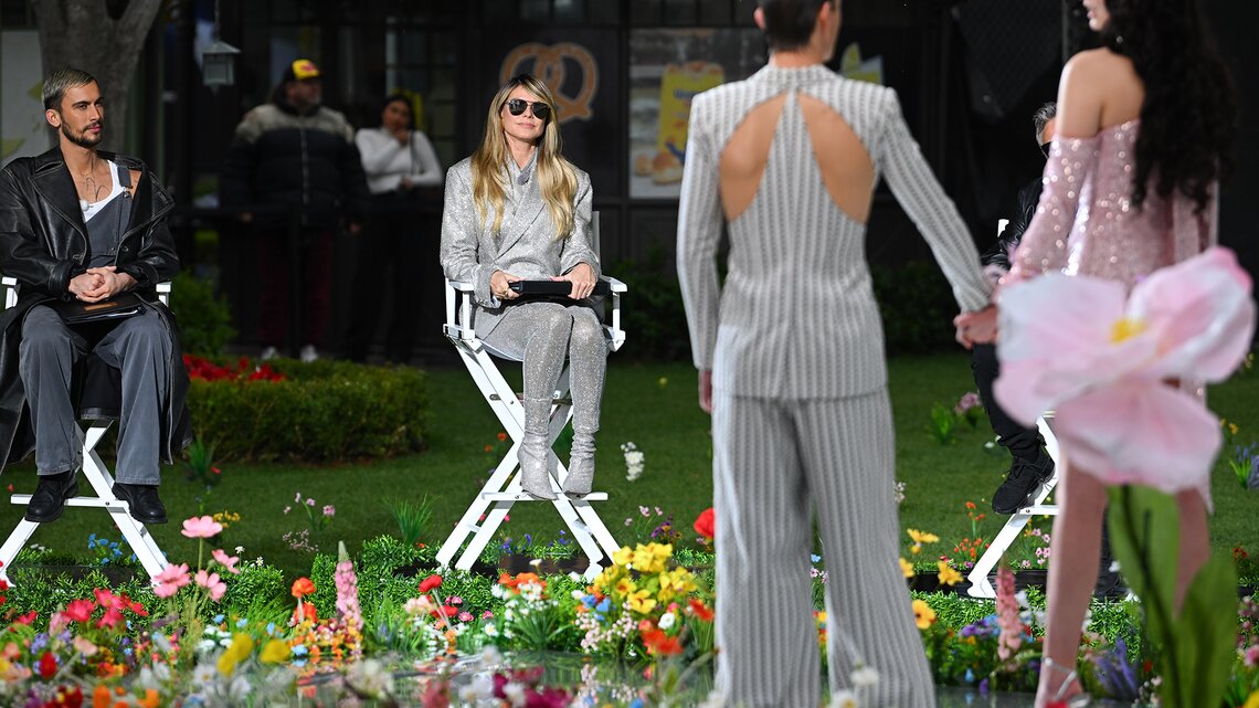 GNTM 2025: Heidi Klum in der Jury beobachtet zwei Personen auf dem Laufsteg. | © GettyImages/PG/Bauer-Griffin / Kontributor