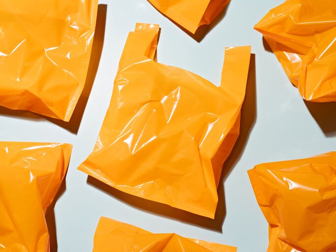 Shoppingtüten in Knallorange | © GettyImages/ MirageC