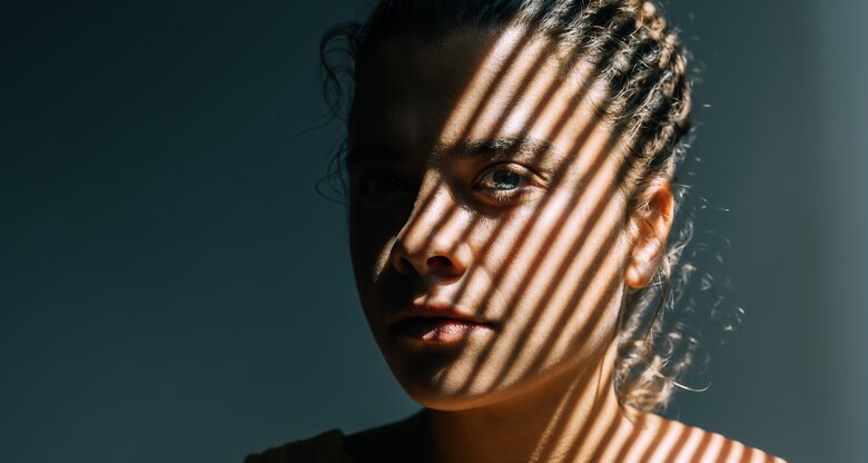 Portrait einer Frau mit Schatten im Gesicht | © GettyImages/	Tatiana Maksimova