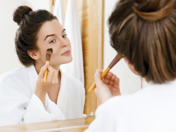 Frau schminkt sich vor dem Spiegel | © Getty Images/Anatolijs Jascuks / EyeEm