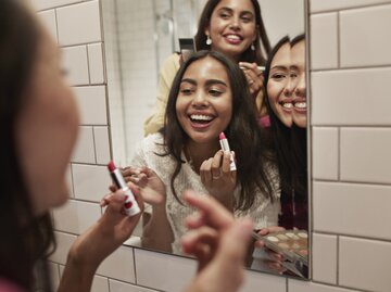 Junge Frauen schminken sich vor dem Spiegel | © Getty Images/Klaus Vedfelt