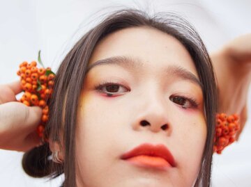 Portrait einer jungen Frau mit Beeren | © Getty Images/Andriy Onufriyenko