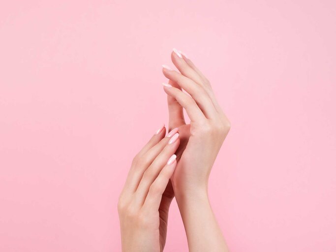 Hände einer Frau vor einer pinken Wand | © Getty Images/Kseniya Ovchinnikova