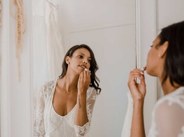 Junge Braut schminkt sich vor dem Spiegel | © Getty Images/Westend61
