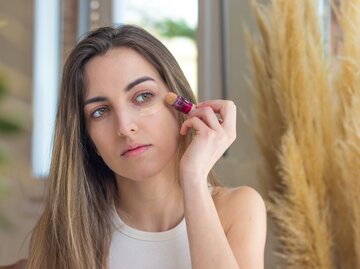 Eine junge Frau trägt sich Makeup auf | © GettyImages/Pablo Vivaracho Hernandez