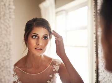 Braut betrachtet sich im Spiegel | © Getty Images/Hiraman