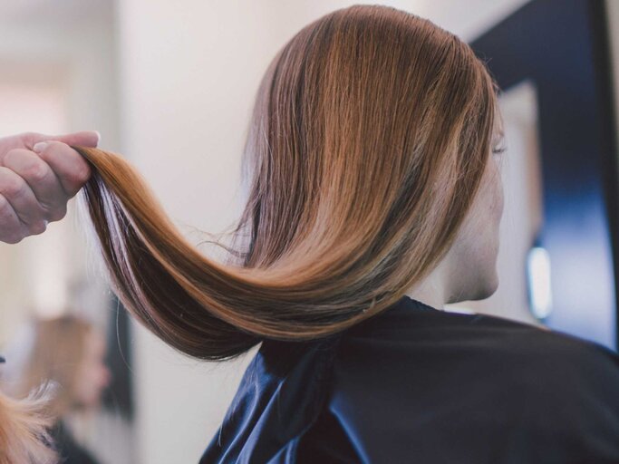 Frau werden Haare beim Friseur geschnitten | © Getty Images/Guido Mieth
