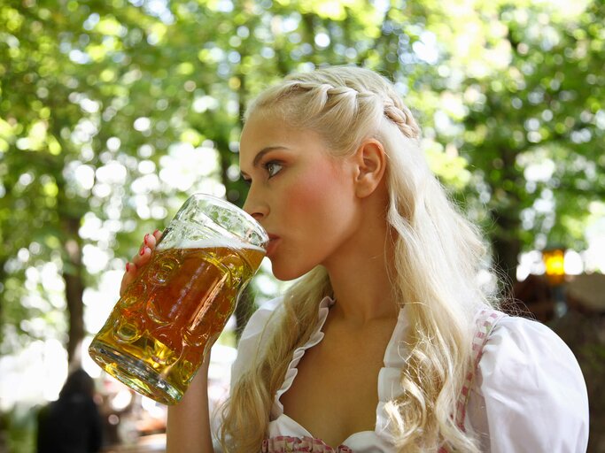 Schöne Frau in Dirndl trinkt Bier | © Getty Images/Cultura RM Exclusive/Photolove