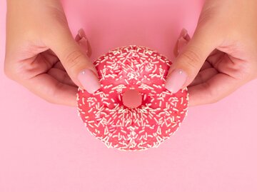 Frau hält Donut in ihren zwei Händen | © Getty Images/Galina Kiseleva