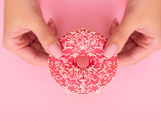 Frau hält Donut in ihren zwei Händen | © Getty Images/Galina Kiseleva