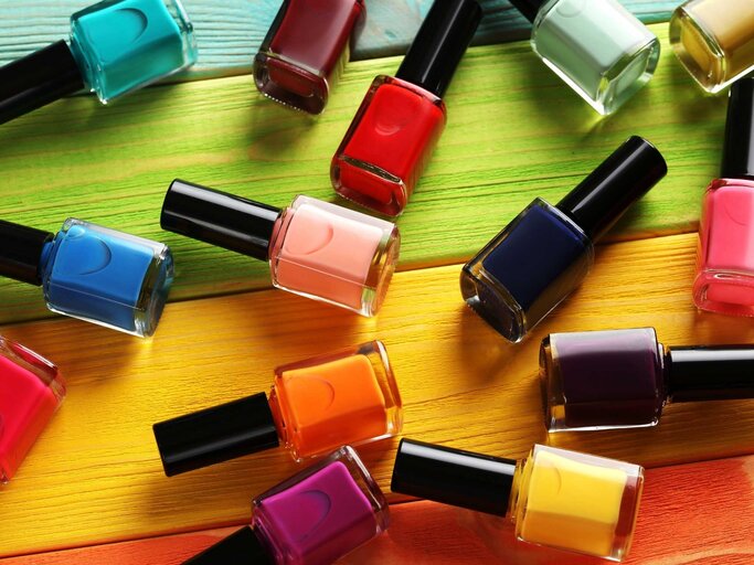 Bunte Nagellackflaschen auf holzernem Tisch | © shutterstock/5 second Studio