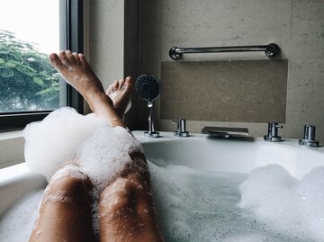 Frau badet und hat die Füße auf dem Badewannenrand | © Getty Images/Aliaksandra Ivanova / EyeEm
