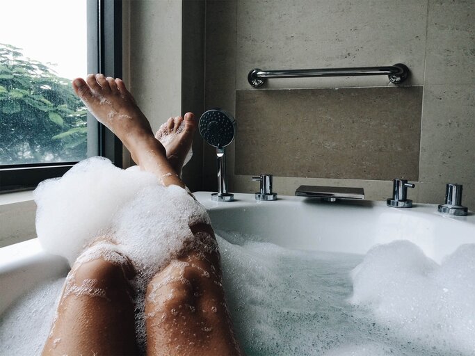 Frau badet und hat die Füße auf dem Badewannenrand | © Getty Images/Aliaksandra Ivanova / EyeEm