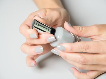 Nahaufnahme einer Frau, die sich die Fingernägel lackiert | © Getty Images/Yulia-Images